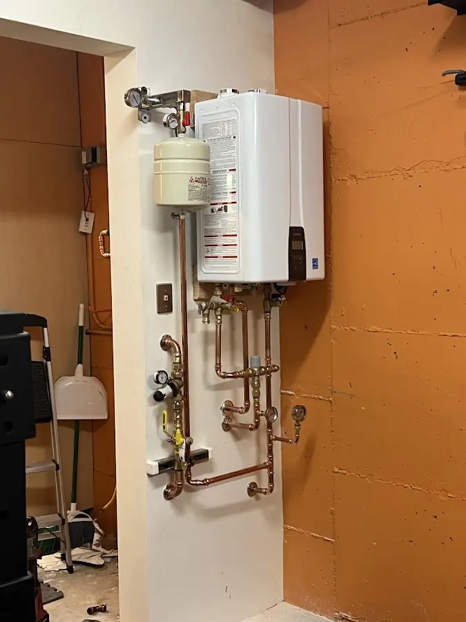 Plumbing technician inspecting water heater connections in Alamogordo